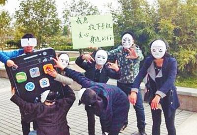 浙江一所大学的学生戴面具呼吁人们不做“低头族”